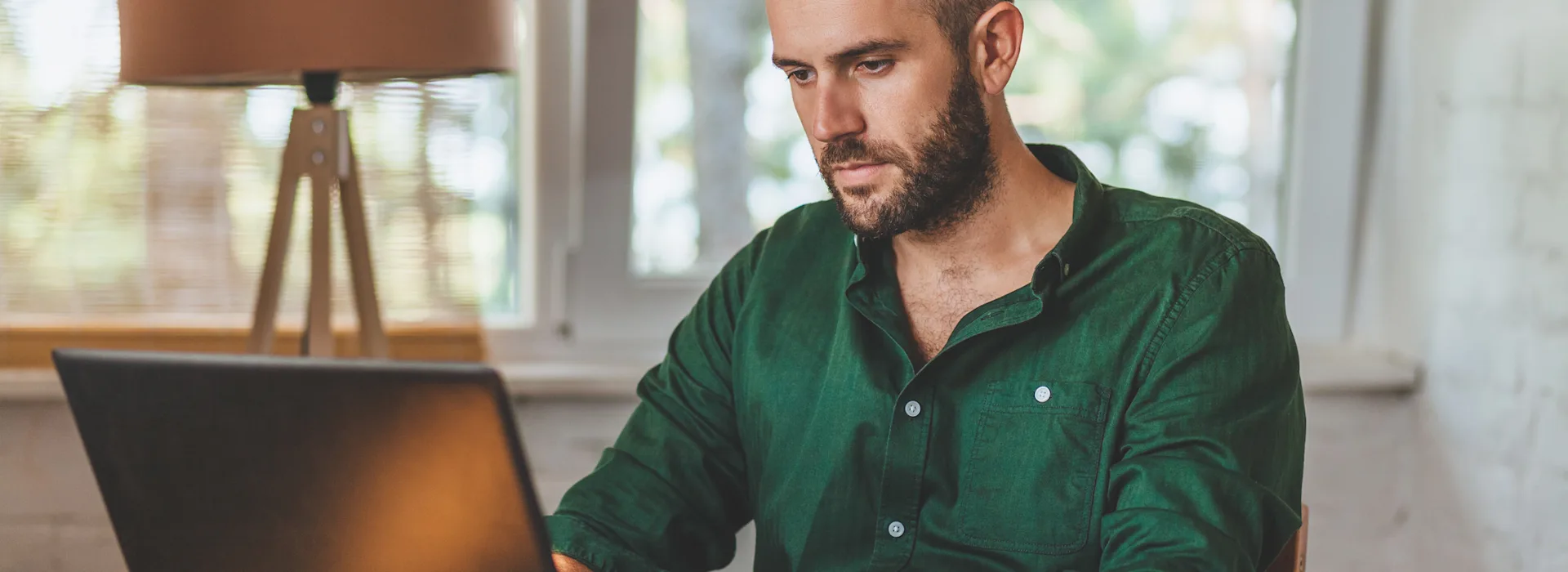 Mann nachdenklich am Laptop Ein Mann sitzt nachdenklich an einem Tisch vor seinem Laptop. Er vergleicht Tarife der NEW Energie.