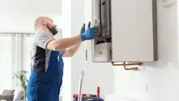 Heizungsmonteur montiert Heizung Ein Heizungsmonteur montiert eine Heizung der NEW Energie in einem Gebäude.