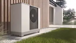 Wärmepumpe im Außenbereich Eine Wärmepumpe steht an einer Hauswand im Außenbereich.
