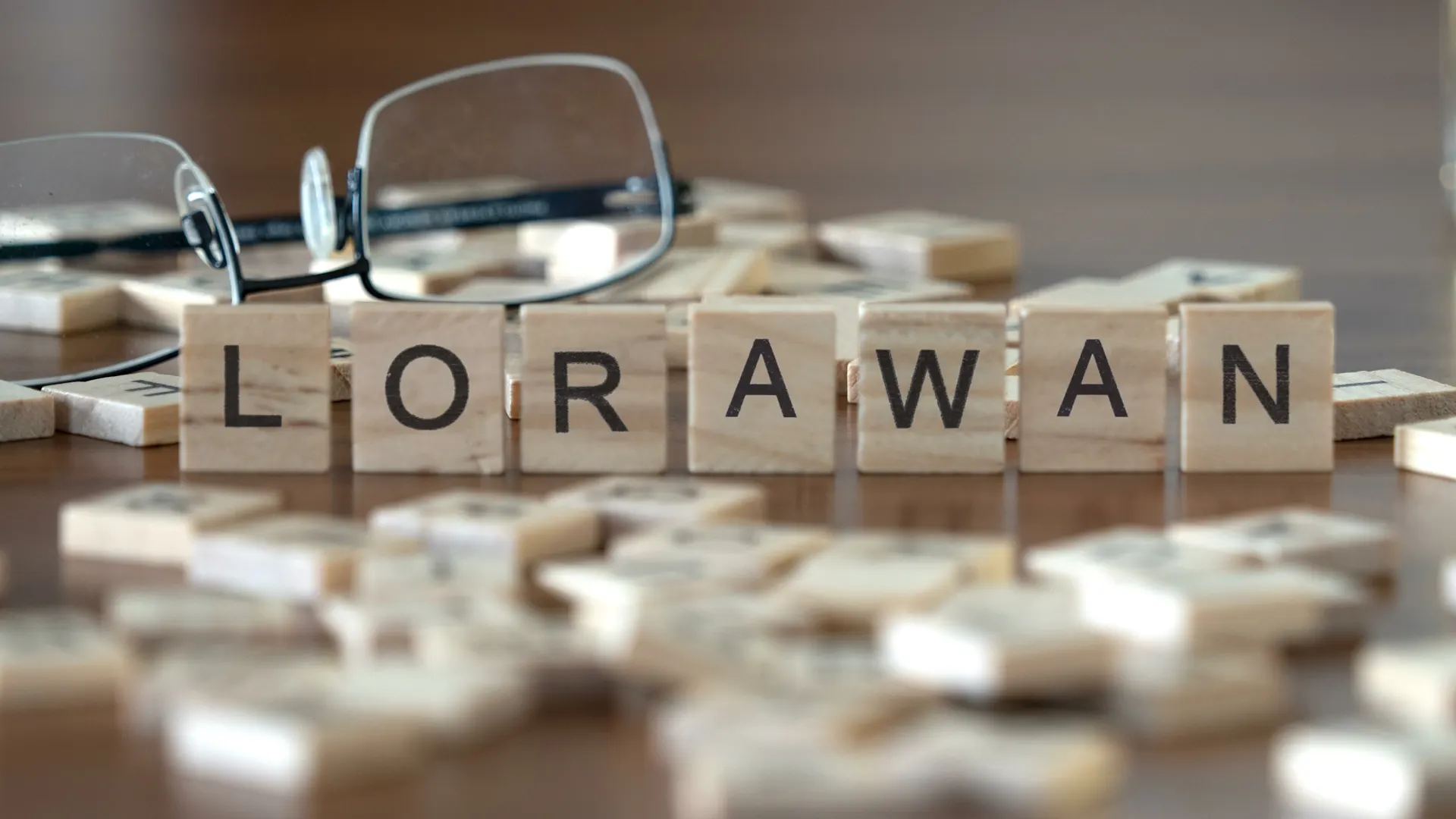 LoRaWAN im Fokus Auf einem Holztisch liegen Scrabble-Buchstaben, die das Wort „LoRaWAN“ bilden.