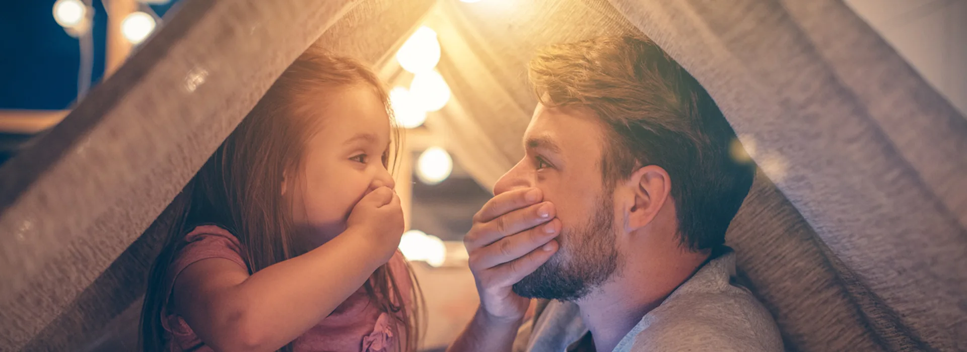 Vater und Tochter freuen sich über günstigen Strom Vater und Tochter sitzen im Wohnzimmer unter einer Deckenhöhle und freuen sich über günstigen Strom der NEW Energie.