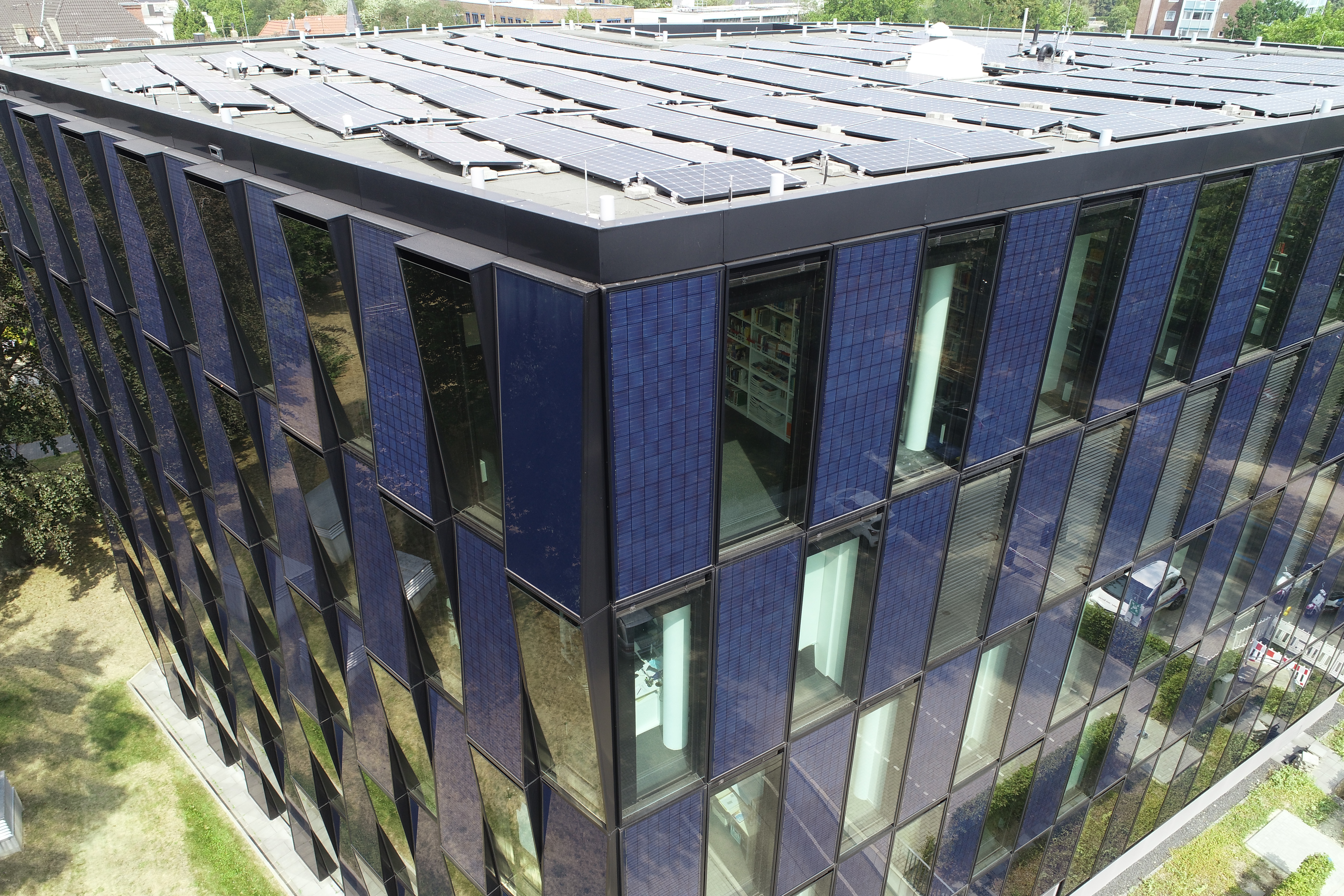 Ein Gebäude ist mit Solarzellen der NEW Energie an der Außenfassade ausgestattet.