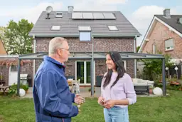 Beratung Photovoltaikanlage Ein NEW Mitarbeiter berät eine Kundin vor ihrem Einfamilienhaus bezüglich einer Photovoltaikanlage von der NEW Energie und grüner Energie.