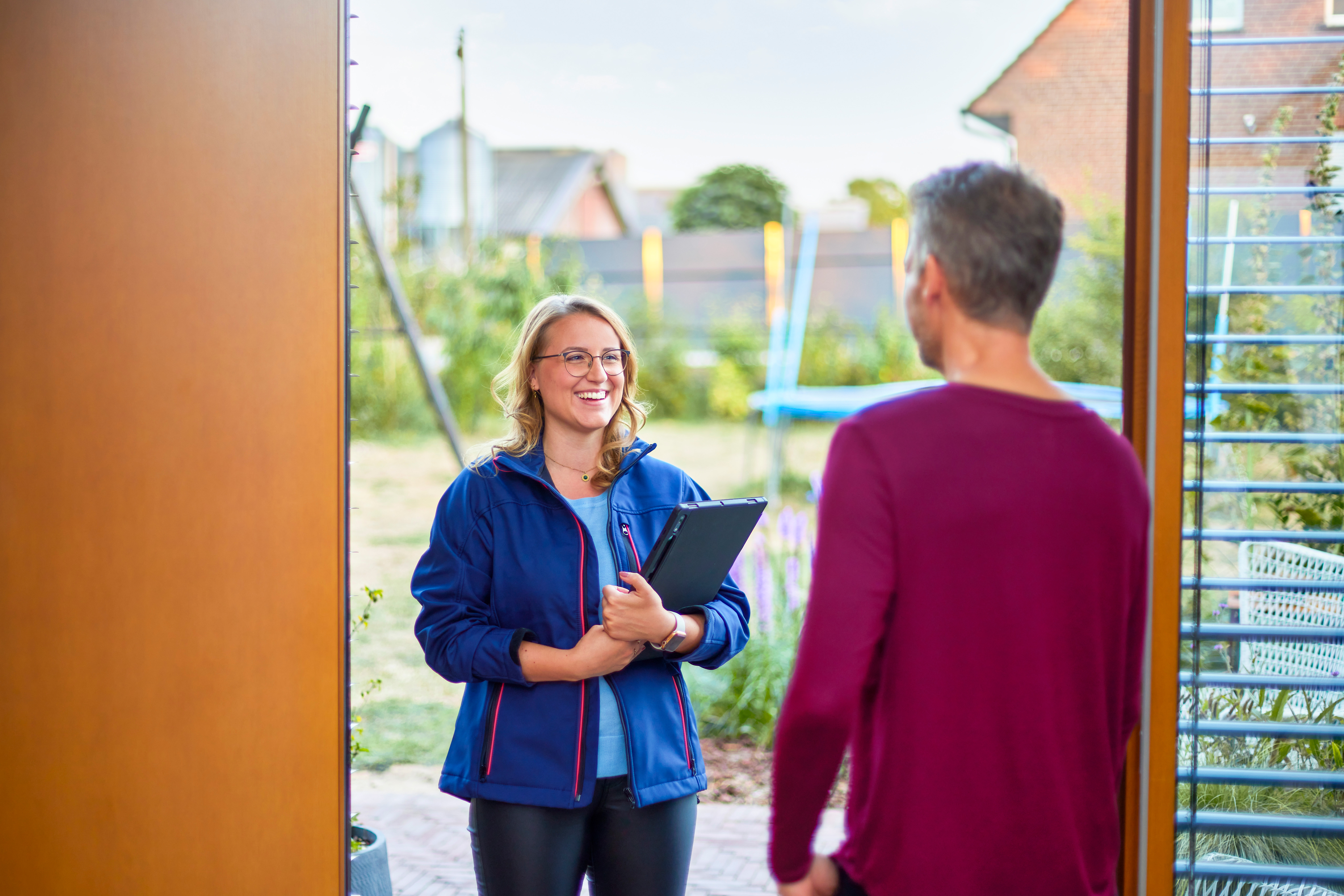 Eine NEW Mitarbeiterin besucht einen Kunden zu Hause. Sie führt eine Beratung durch für eine PV-Anlage von der NEW Energie.