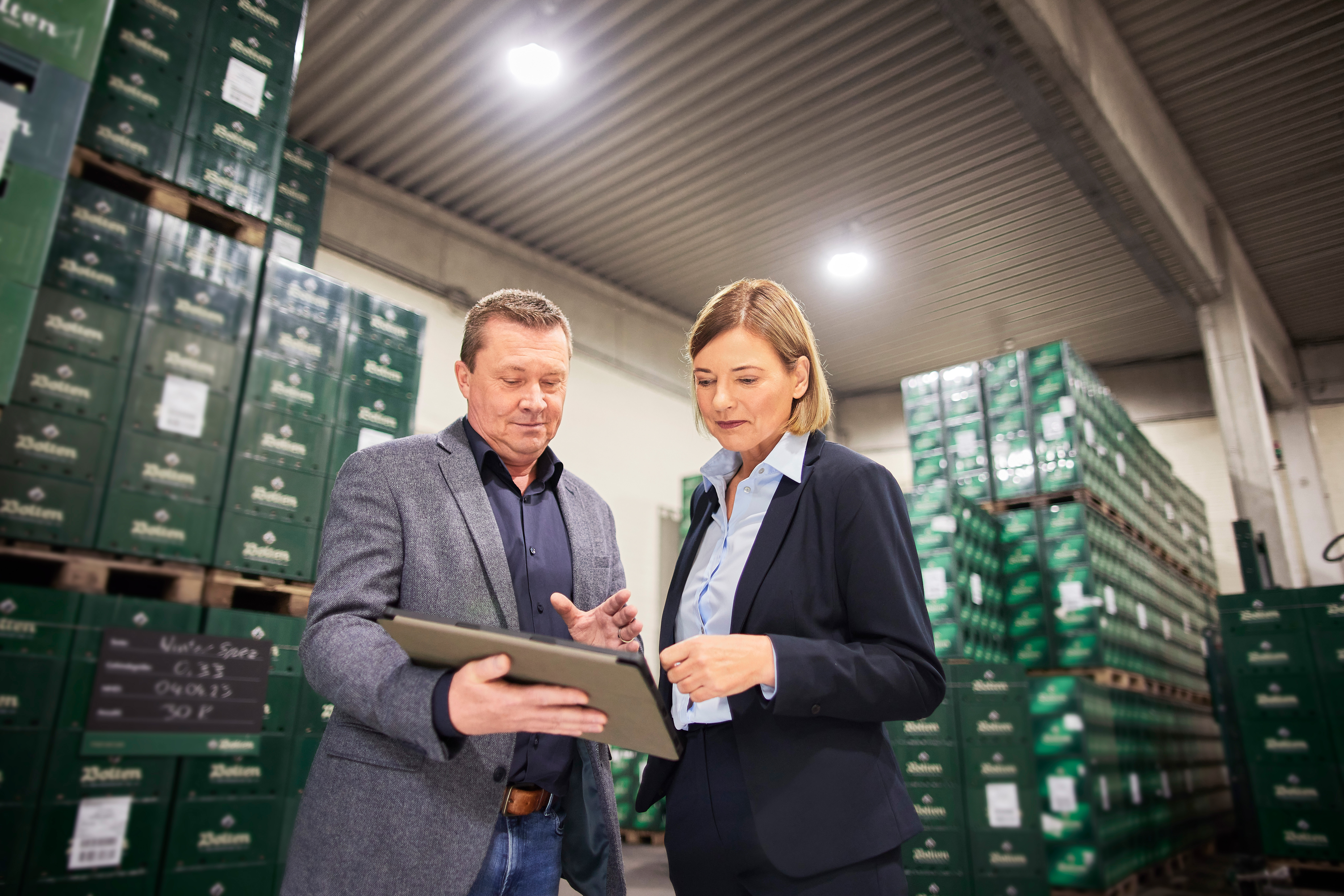 Ein Mitarbeiter der NEW Energie ist bei einer Kundin im Unternehmen in einer Lagerhalle und berät sie.
