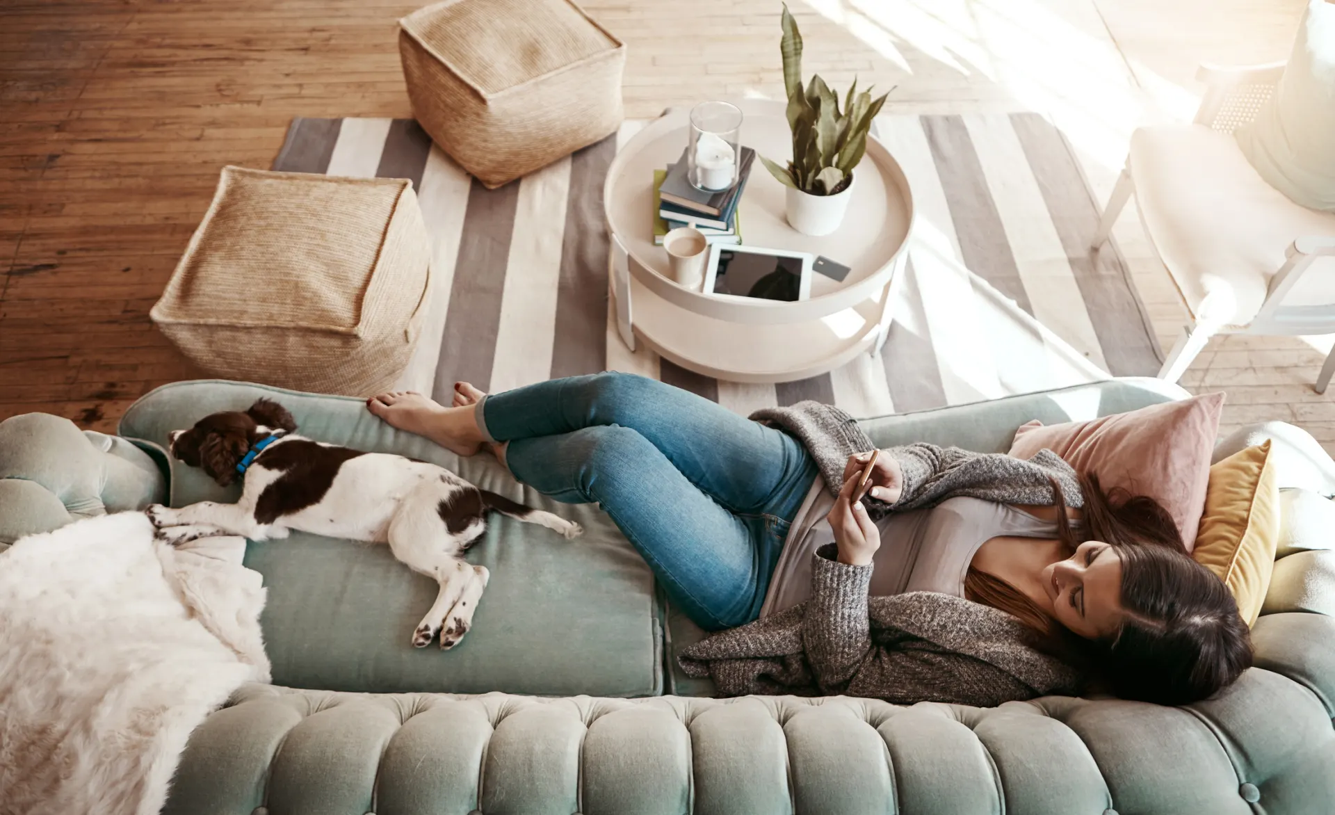 Eine Frau liegt im Wohnzimmer auf dem Sofa und schaut nach Stromtarifen der NEW Energie.