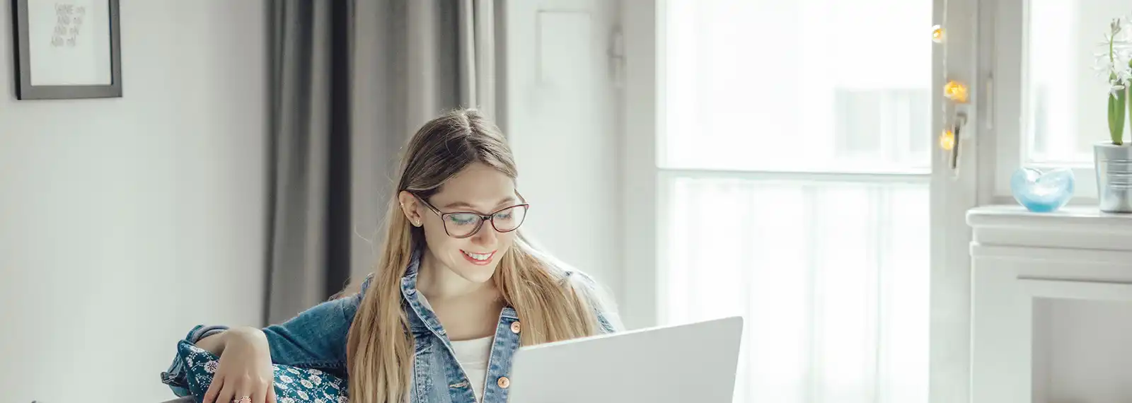 Die Frau sitzt am Laptop und hat eine Anfrage online bestätigt.