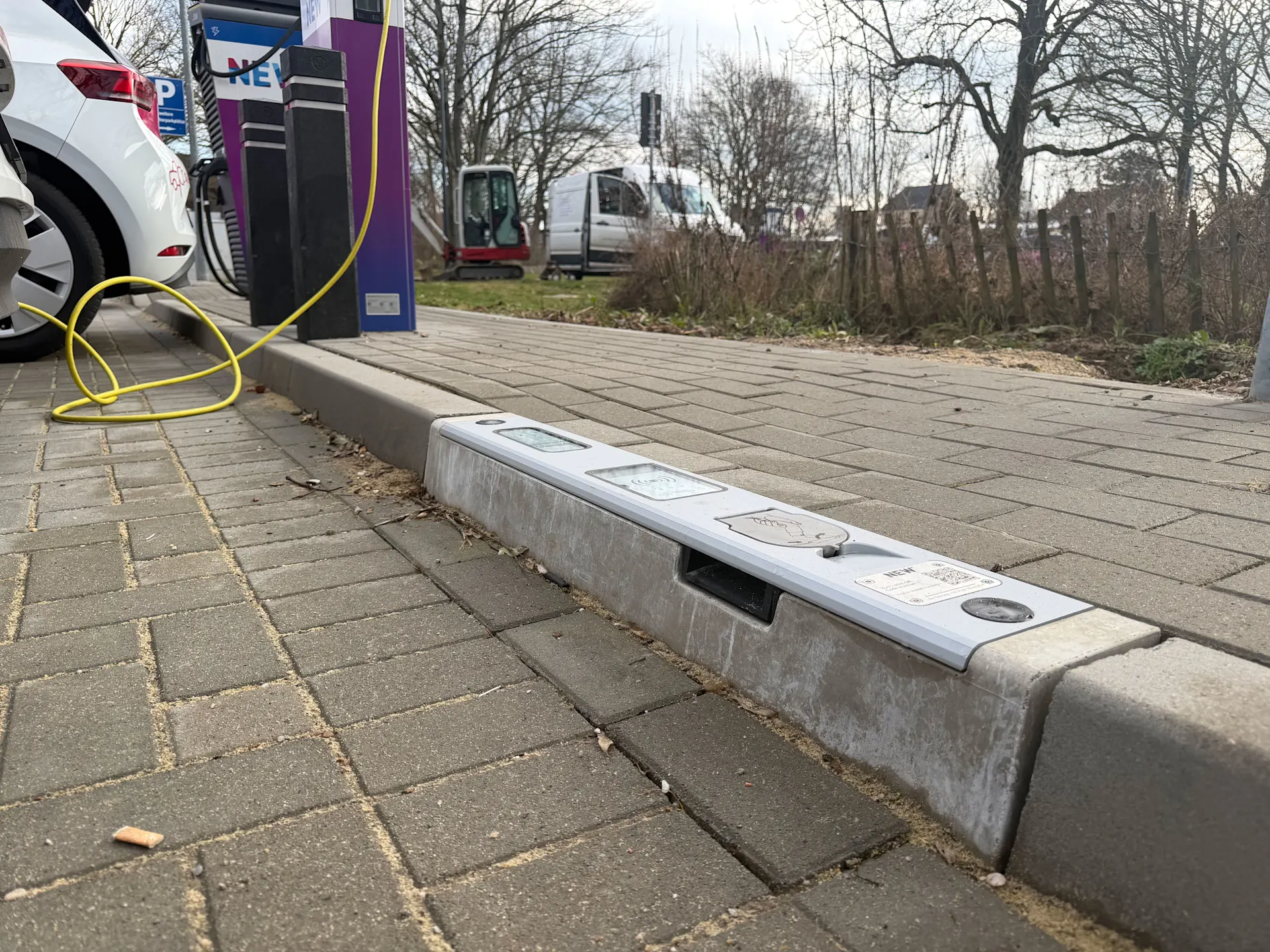 Ladebordstein bei der NEW Energie Auf dem Bild sieht man einen Ladebordstein der NEW Energie. Im Hintergrund steht eine Ladesäule der NEW.