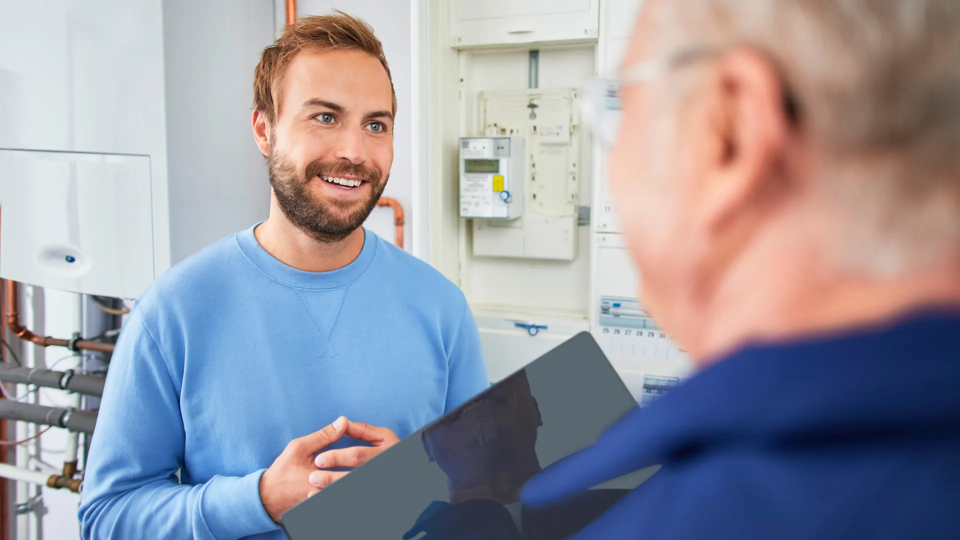 Beratung Kunde Stromzähler und Heizung mieten Ein NEW Energie Mitarbeiter berät einen Kunden bezüglich eines Stromzählers.