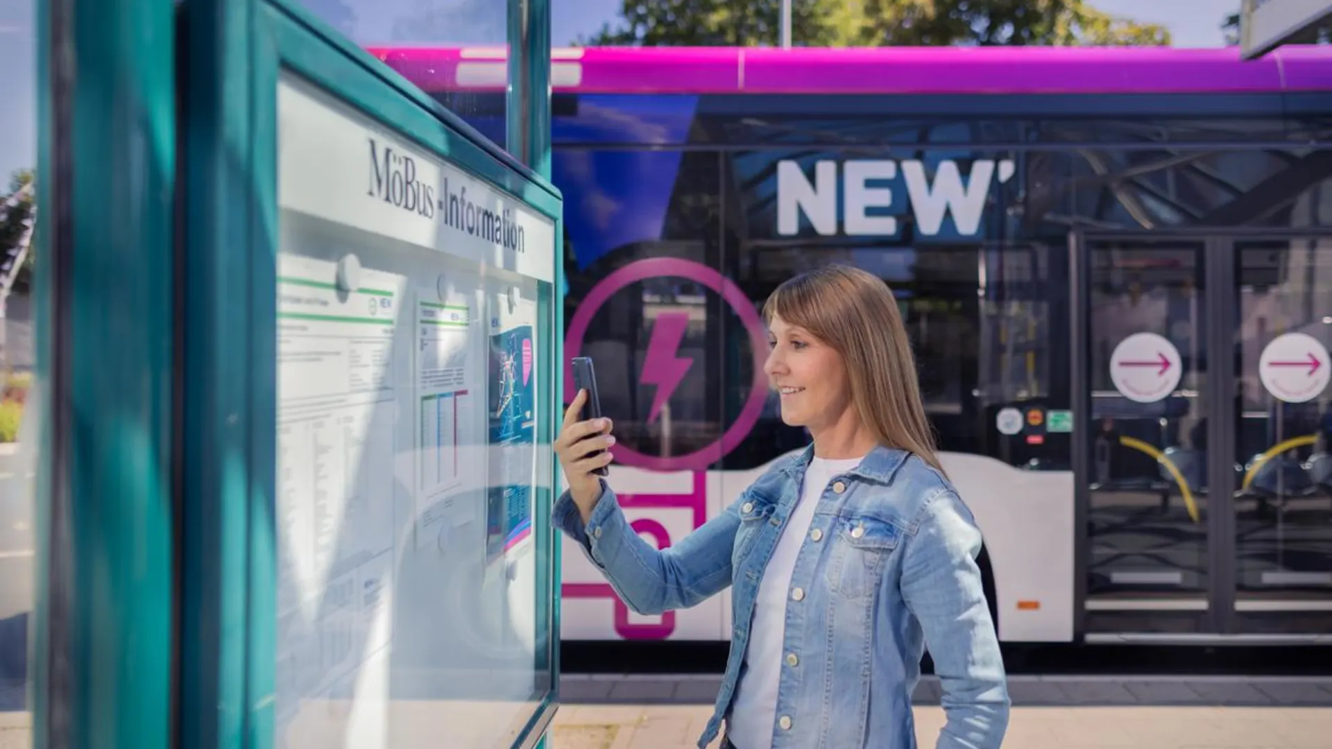 Fahrplanänderungen Weiblicher Fahrgast die mit ihrem Handy an der Bushaltestelle Fahrplanänderungen prüft.