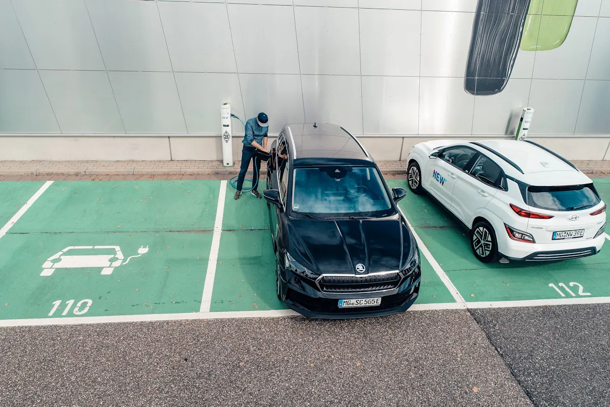 Ein Mann lädt sein Elektroauto an einer öffentlichen Ladesäule.