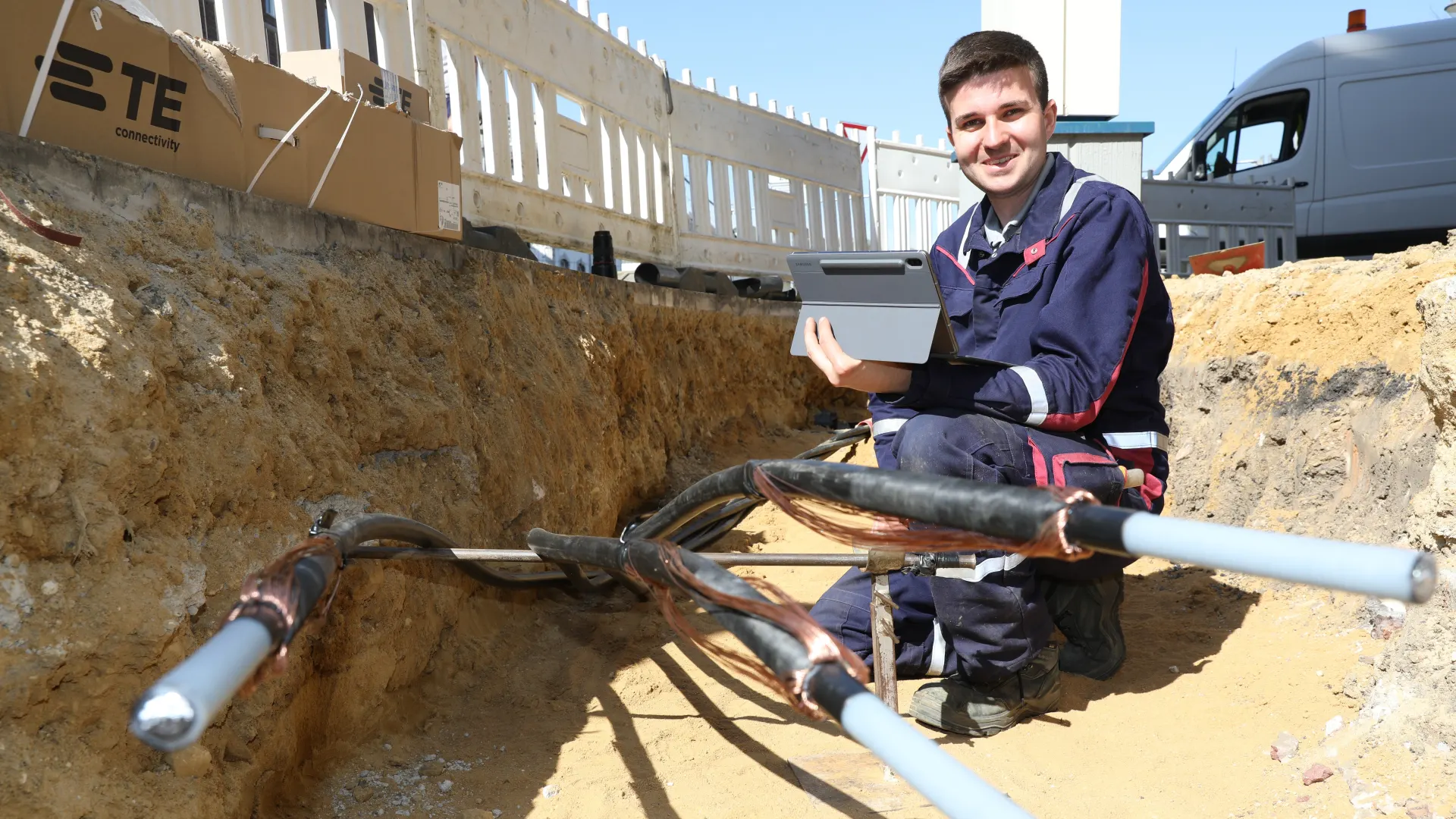 Mitarbeiter im Kabelgraben bereitet eine 20KV Verbindungsmuffe vor.