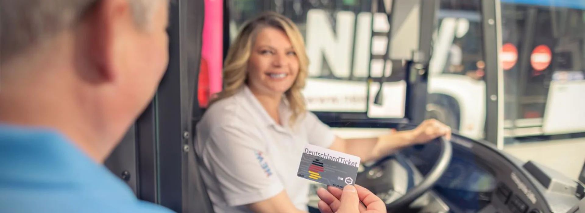 Fahrgast zeigt der Busfahrerin sein DeutschlandTicket Fahrgast zeigt der Busfahrerin sein DeutschlandTicket