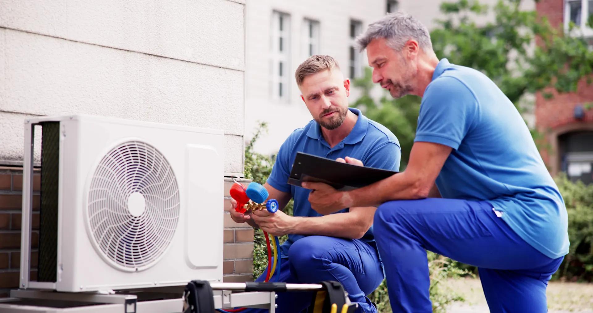 Zwei Männer installieren eine Wärmepumpe.