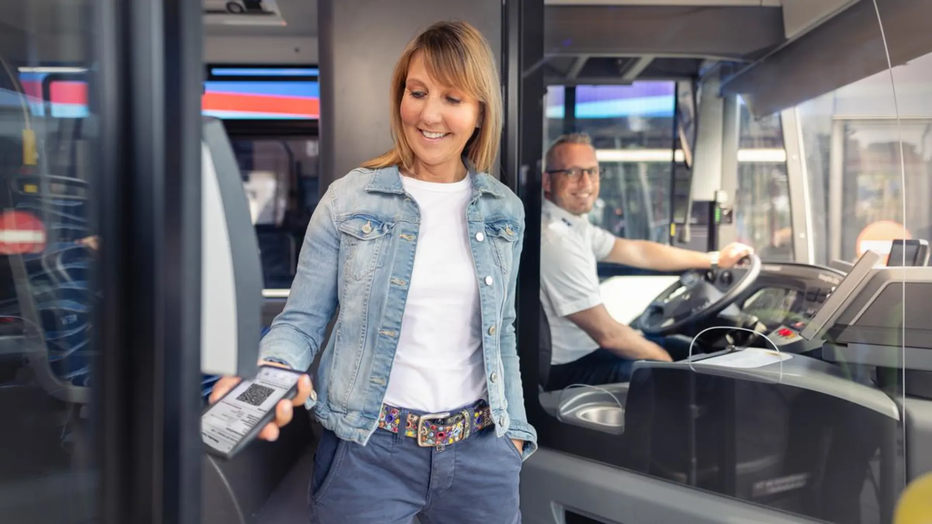 Eine Mitfahrende zahlt im Bus digital mit dem EEZY-Ticket Eine Mitfahrende zahlt im Bus digital mit dem EEZY-Ticket