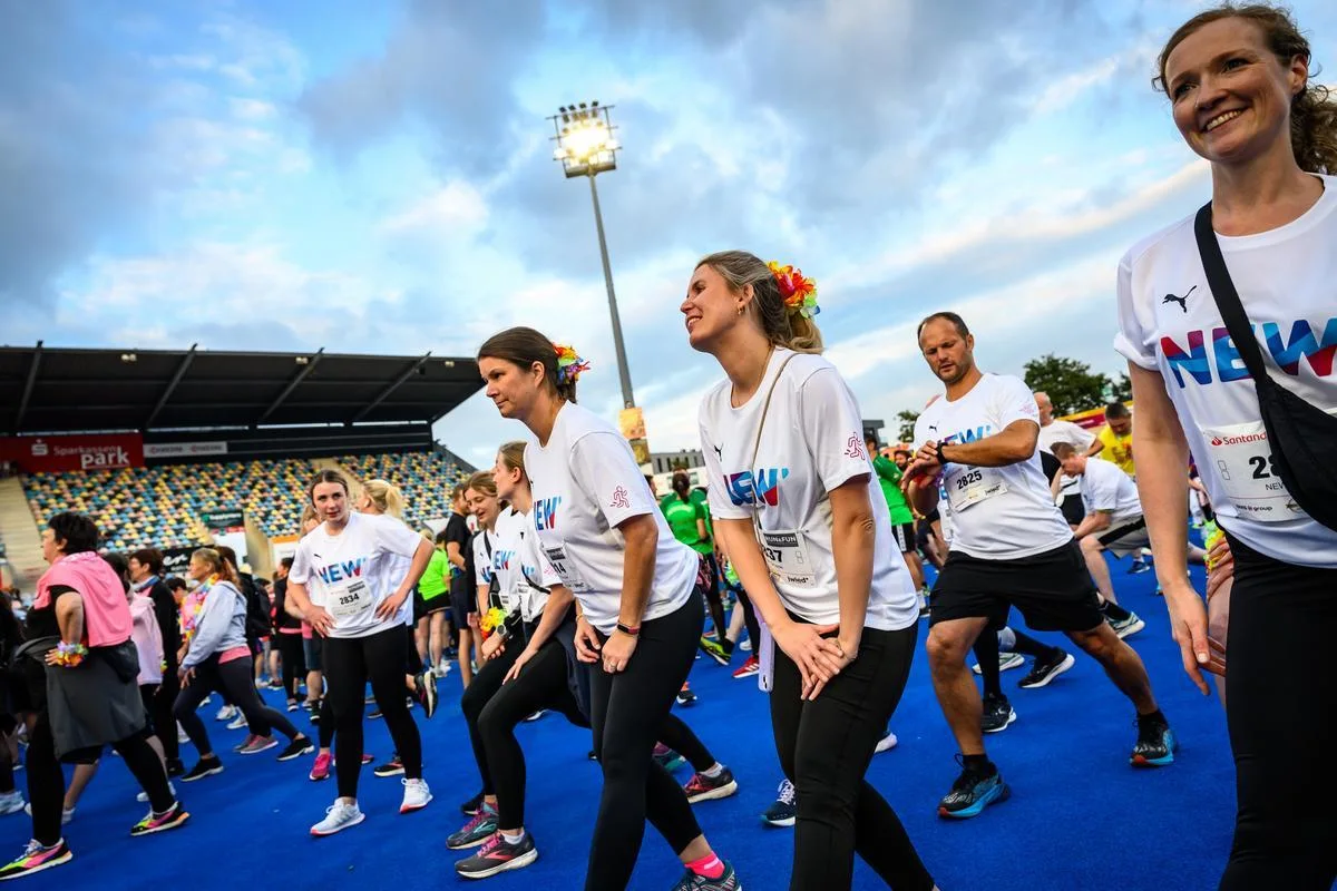 NEW Mitarbeiter:innen wärmen sich zum Run and Fun Lauf auf.