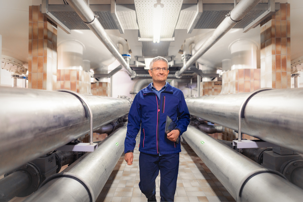 Ein Mitarbeiter läuft durch einen Gang zwischen Trinkwasserversorgungsleitungen