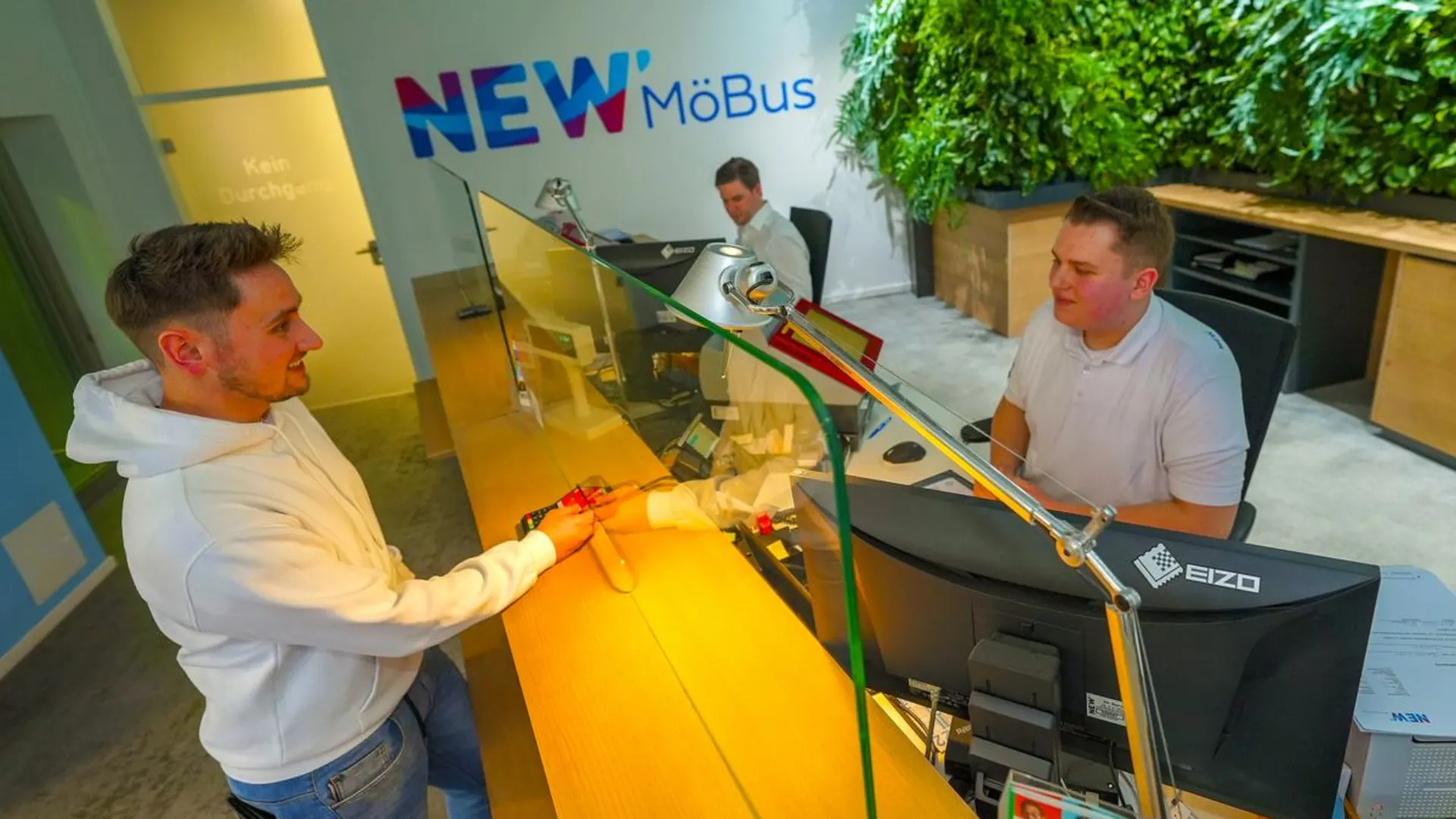 MöBus Kundencenter Kunde im MöBus Kundencenter am Schalter mit zwei NEW Mitarbeitern.