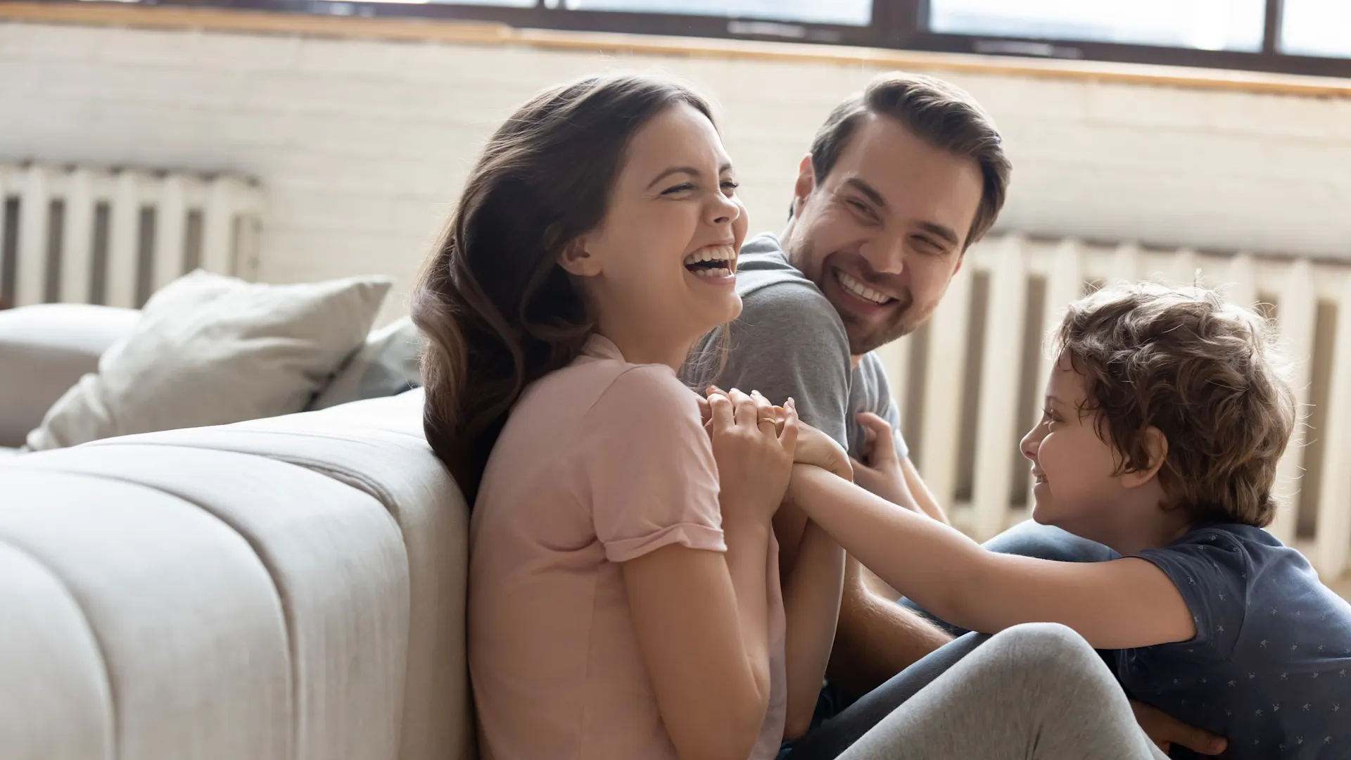 Gastarif sichern Familie sitzt auf dem Boden und spielt.