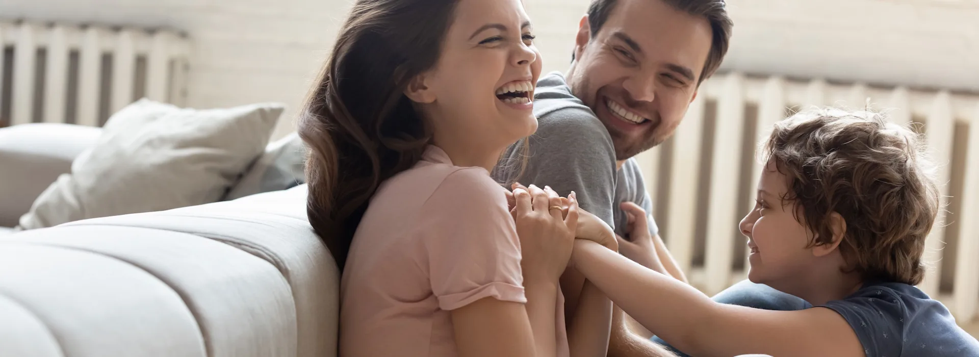Gastarif sichern Familie sitzt auf dem Boden und spielt.