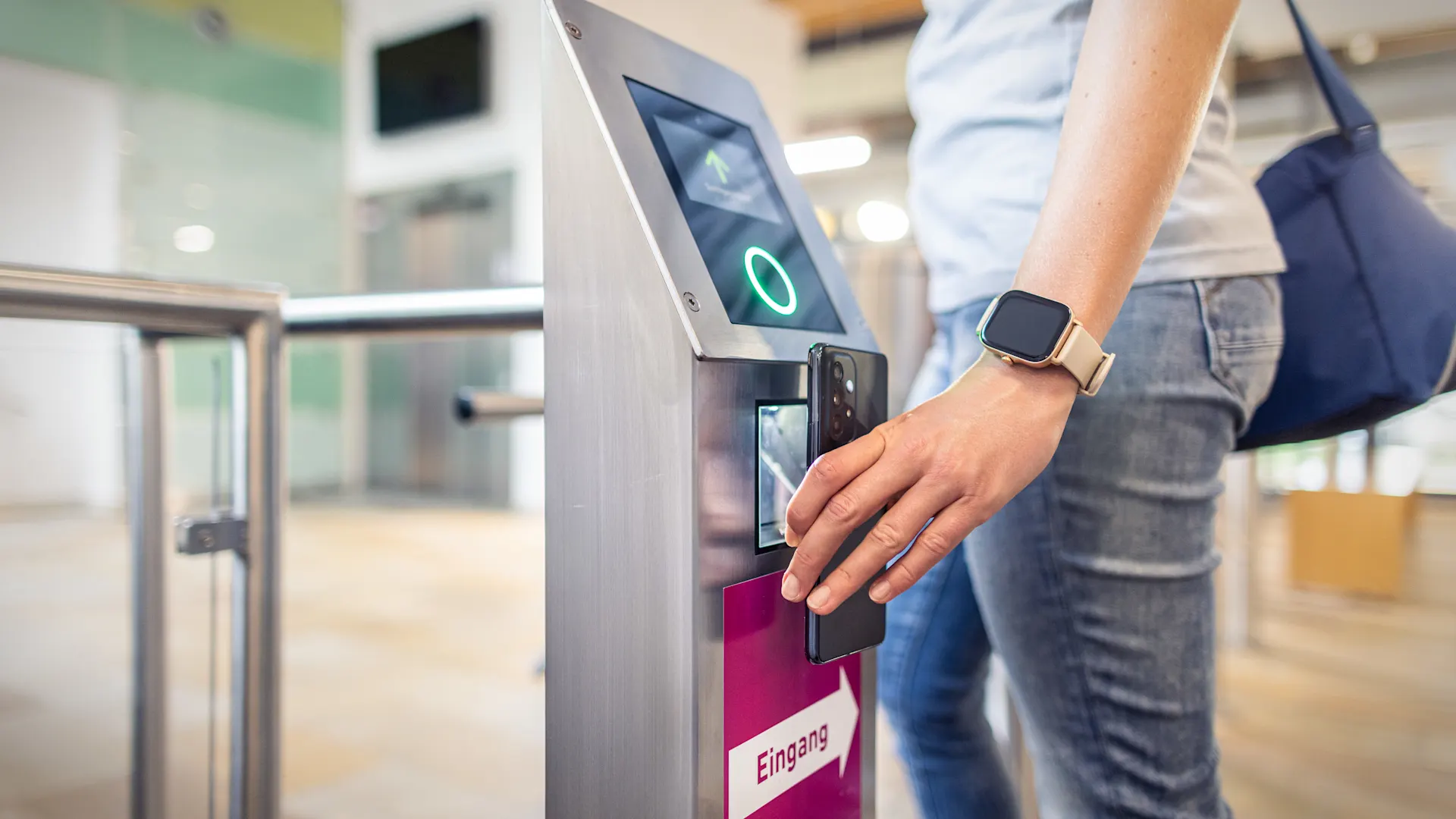 NEW-AG-Baedershop-H8A3789-f Ein Badegast hält für den digitalen Zutritt das Smartphone vor den Scanner im Eingangsbereich.