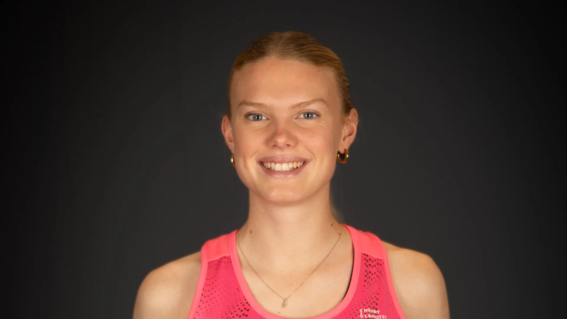 Lilly Stoffelsma in einem pinken Trikot lächelt in die Kamera 