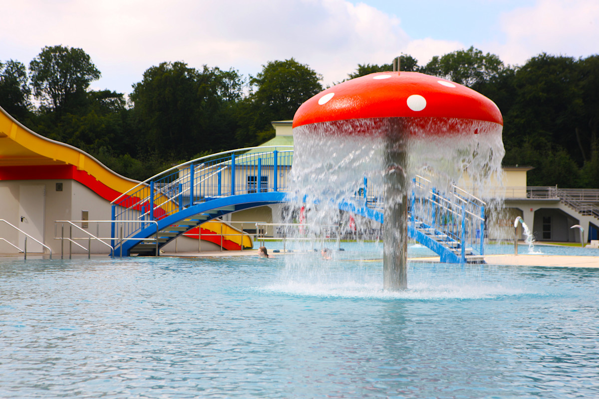 Ein sprudelnder, roter Wasserpilz im Freibad im Volksbad.