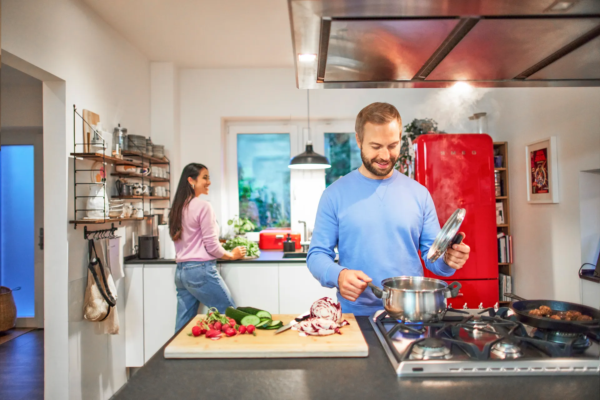 Ein Paar bereitet das Familienessen durch gemeinsames Kochen vor und nutzt dabei die Gastarife mit günstigem Gas der NEW Energie.