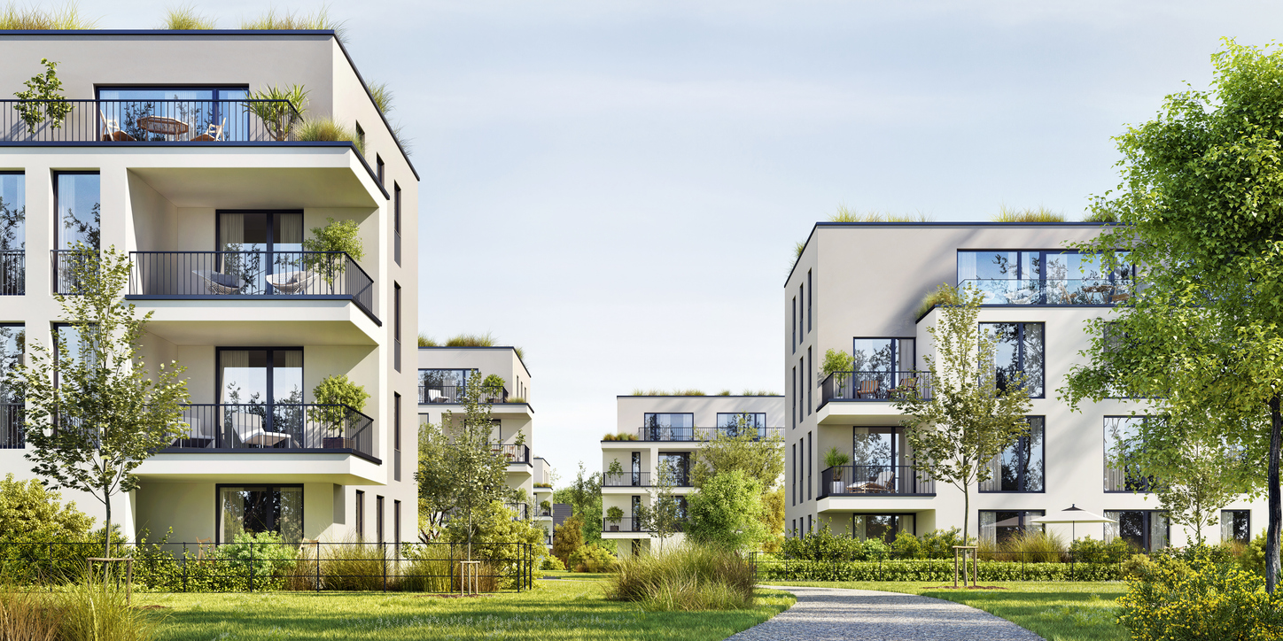 Moderne Wohnanlage mit mehrstöckigen Gebäuden in zeitgenössischer Architektur. Die hellen Fassaden mit großen Fenstern und Balkonen fügen sich harmonisch in eine grüne Parklandschaft ein.